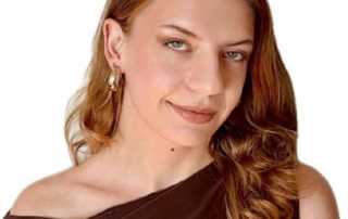 Smiling woman with wavy hair and gold earrings